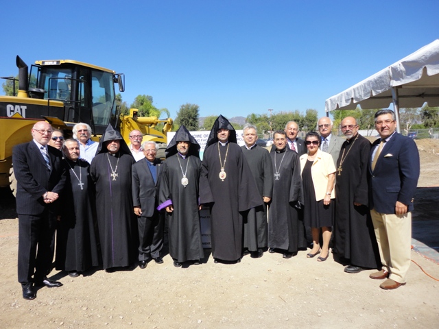 Group of people posing at an outdoor event site.