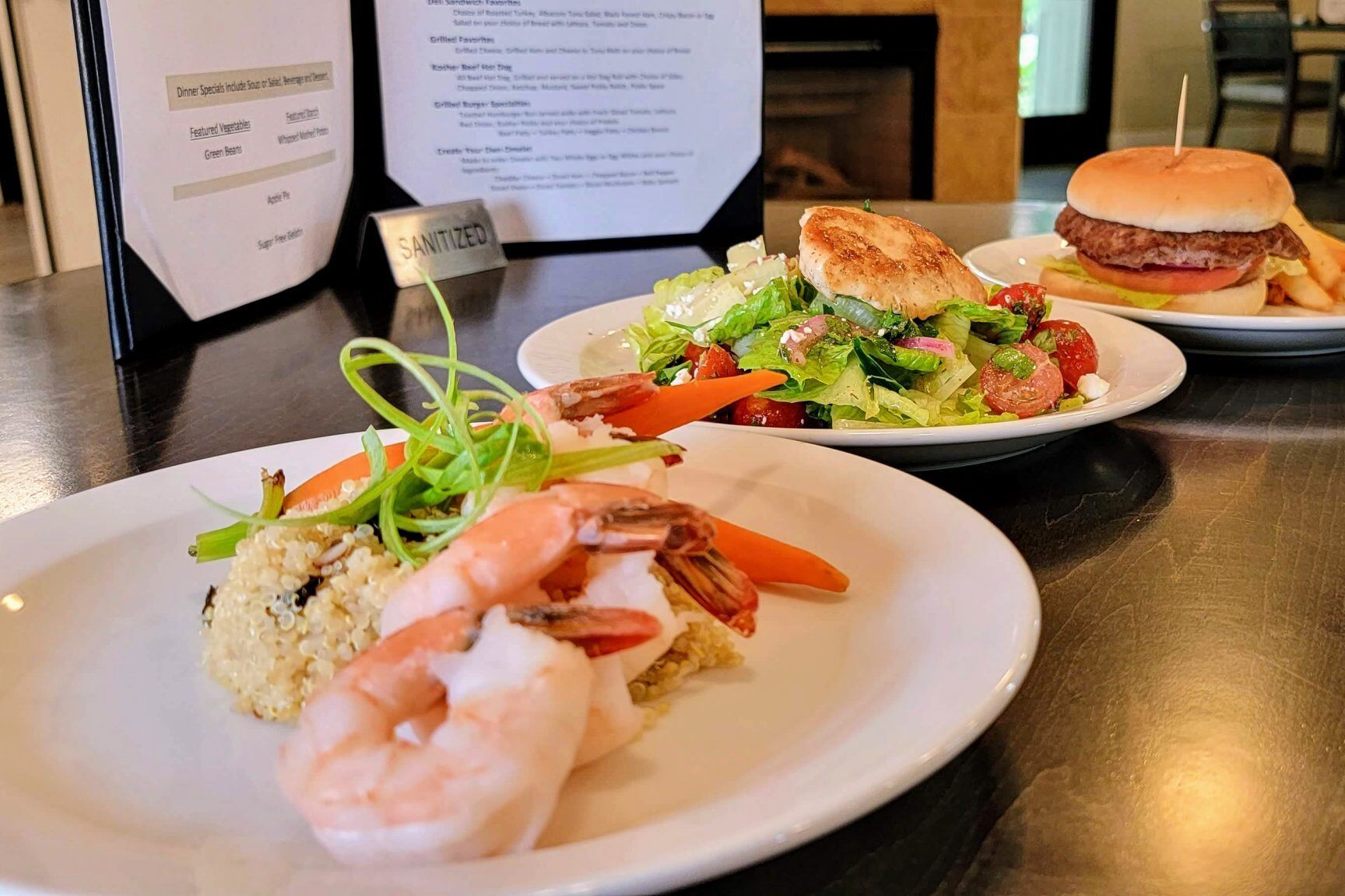 Plated meal with shrimp, salad, and a burger
