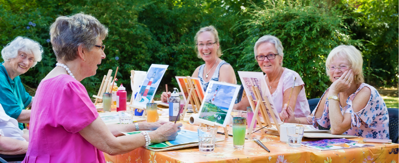 Residents engaged in a painting activity outdoors.