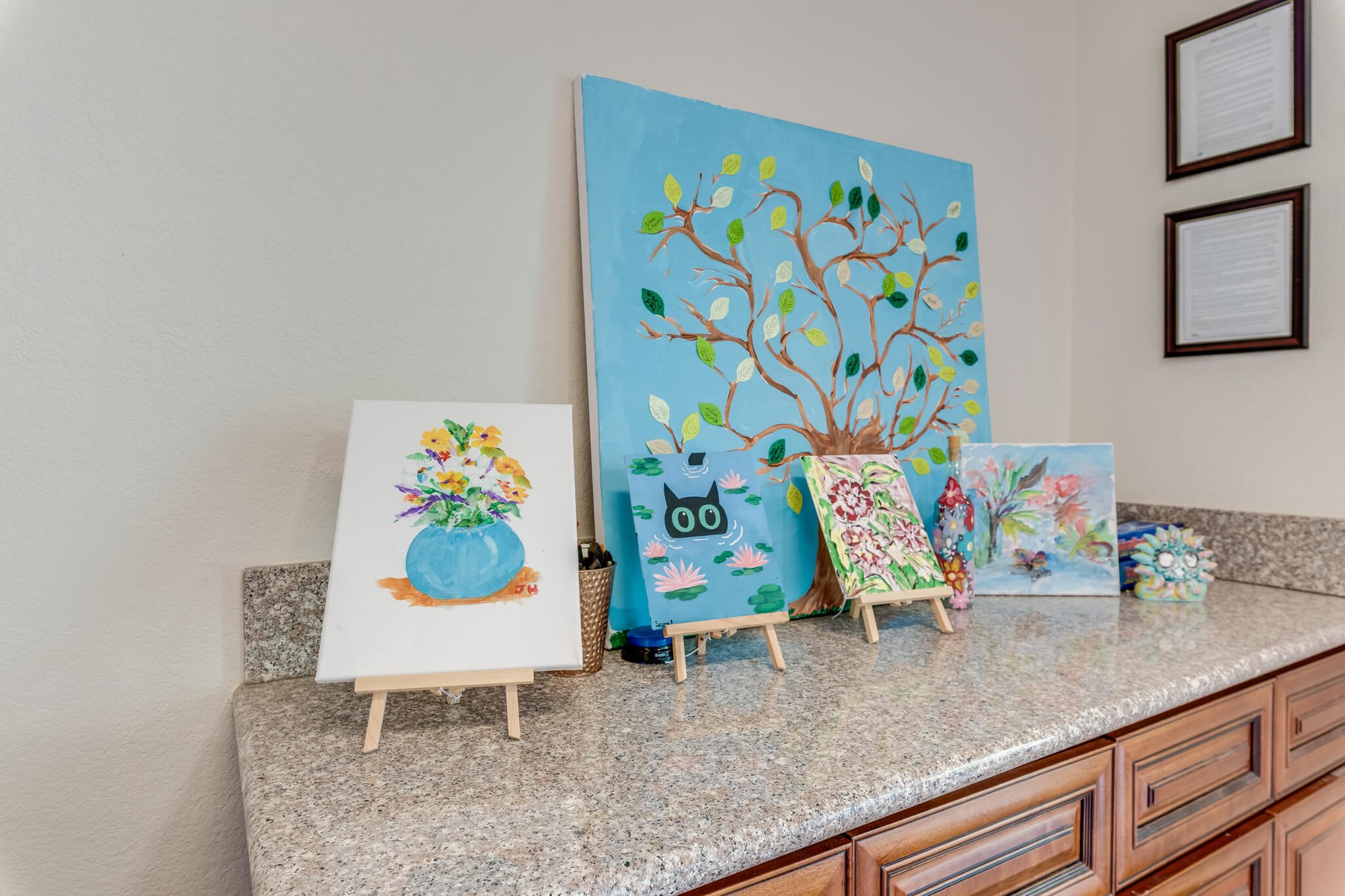 Colorful paintings displayed on a countertop.