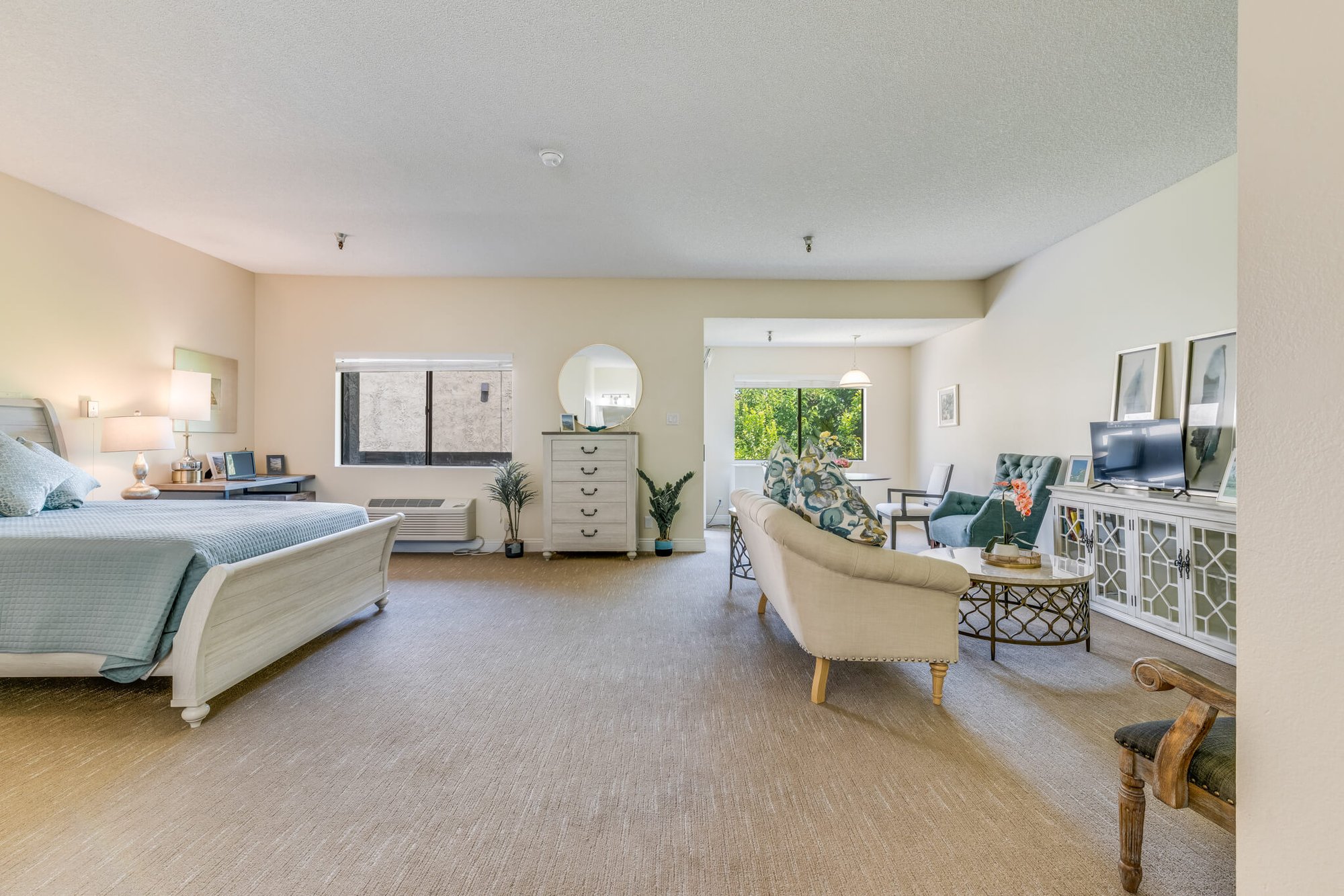 Spacious resident room with seating and light decor.