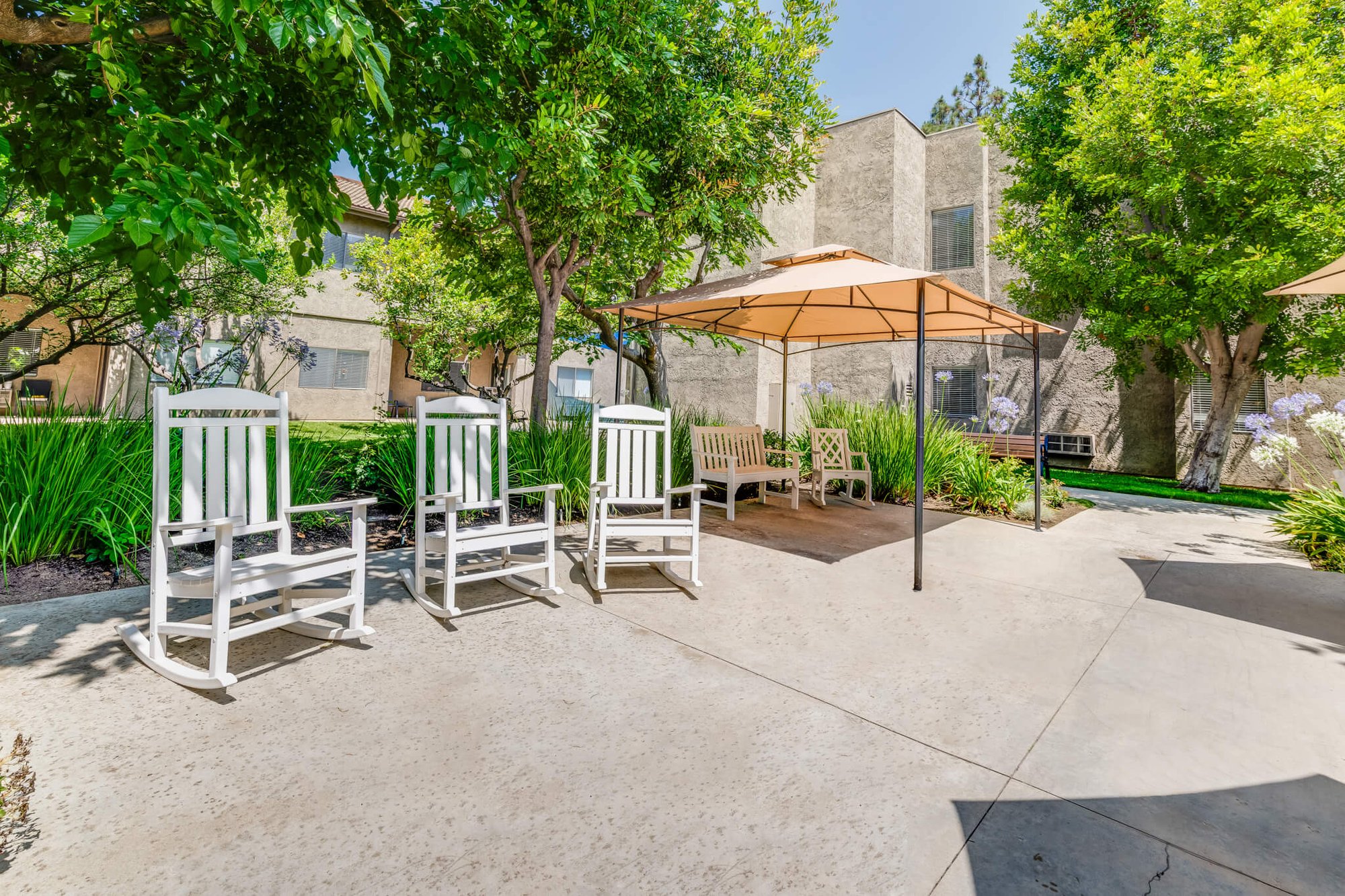 Outdoor seating area with rocking chairs and umbrellas