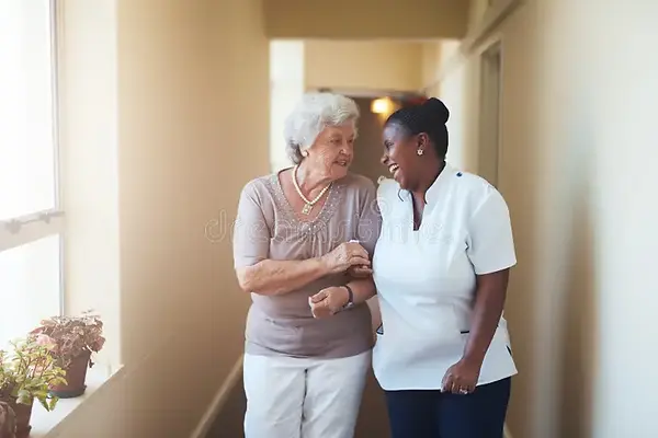 A staff member interacting with a resident in a hallway.