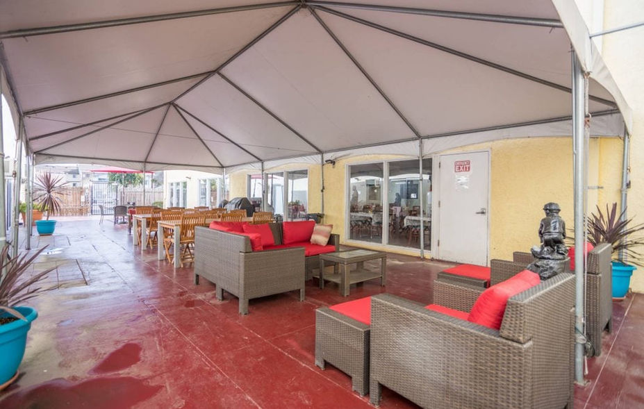 Outdoor seating area with red cushions and tables.
