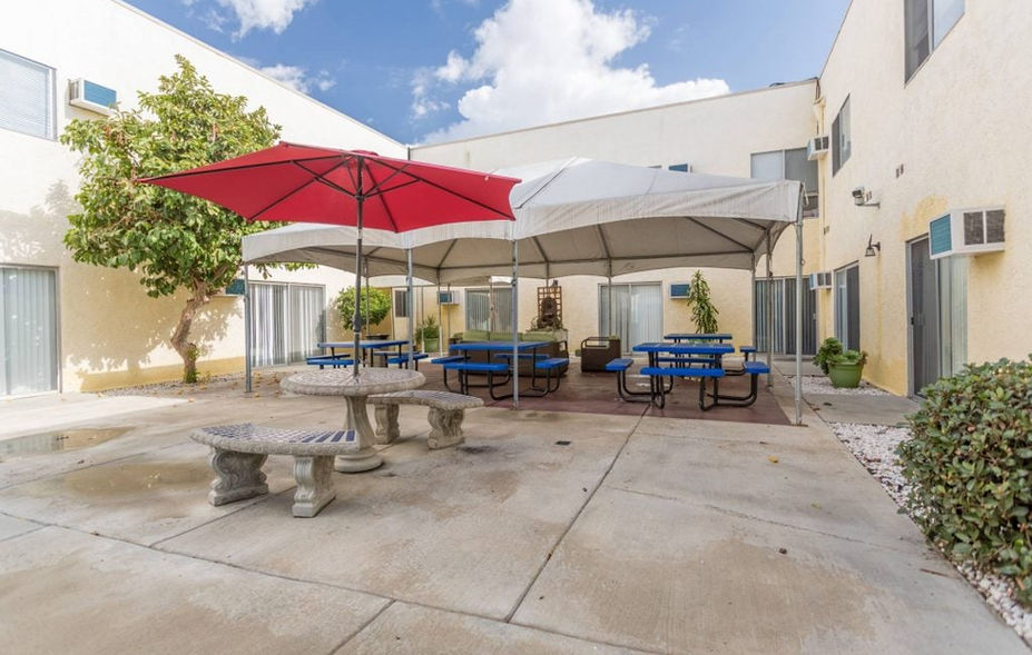 Outdoor courtyard with tables and a tent.