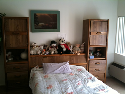 A cozy resident room with a bed and stuffed animals.