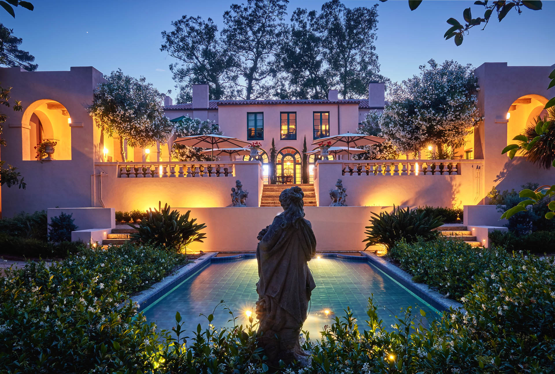 Exterior view of Casa Dorinda at dusk with fountain