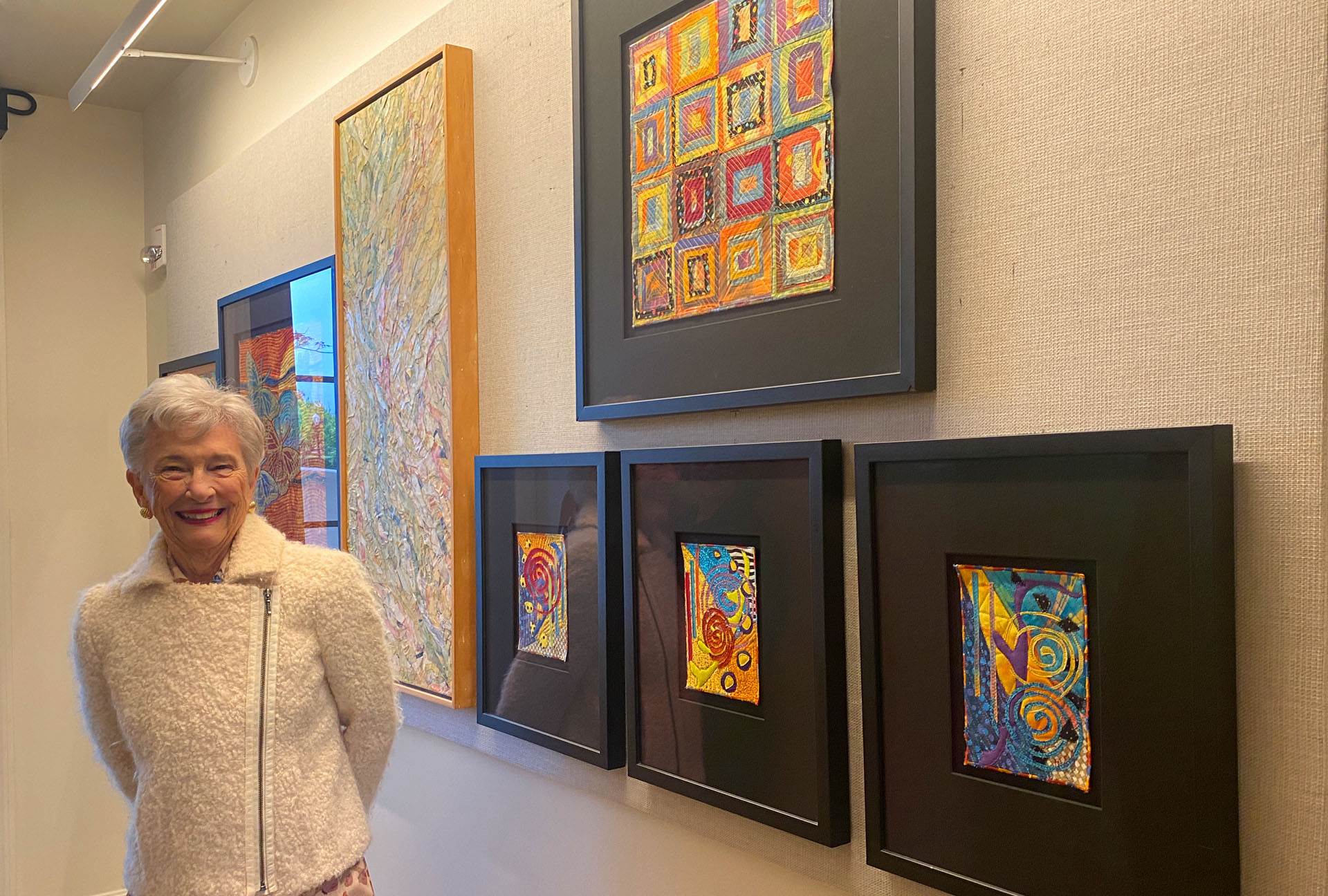 Resident posing beside colorful artwork in common area