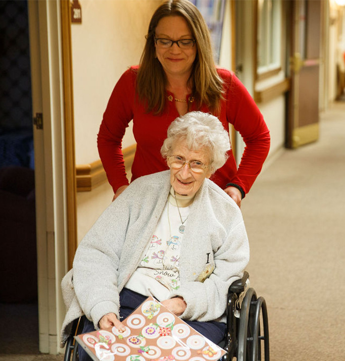 Staff member assisting a resident in a hallway