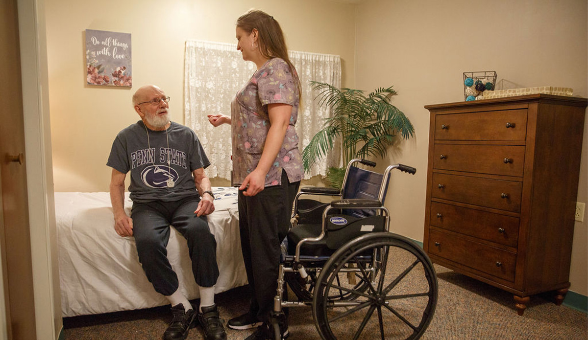 Staff member interacting with resident in their room.