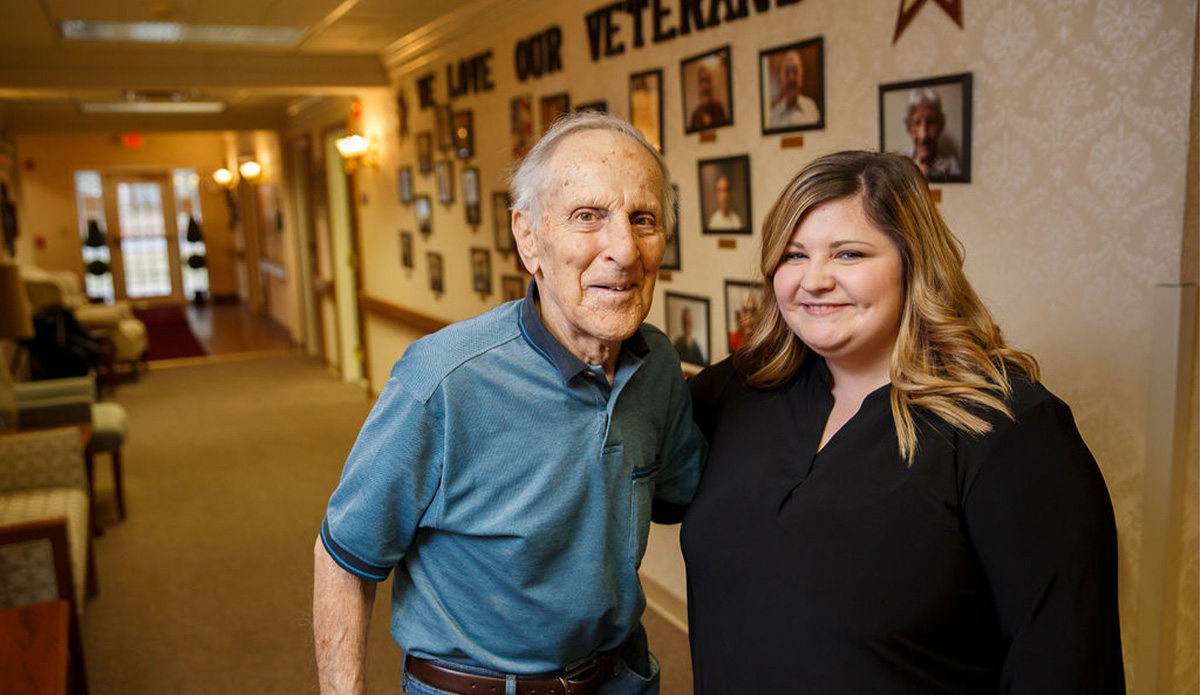 Senior resident with staff member in common area