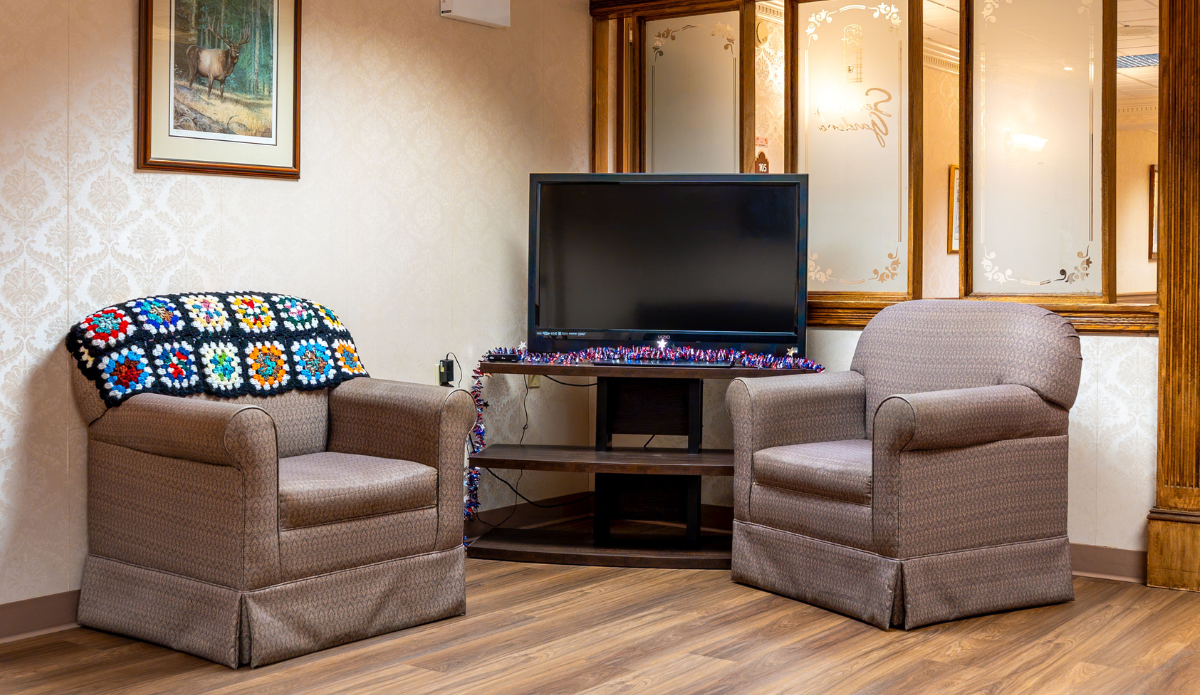 Cozy sitting area with two chairs and a TV.