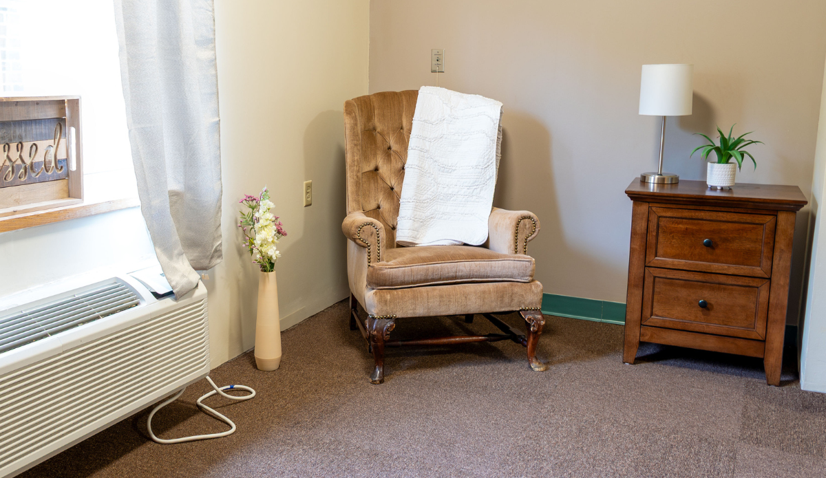 Cozy reading corner with armchair and lamp.