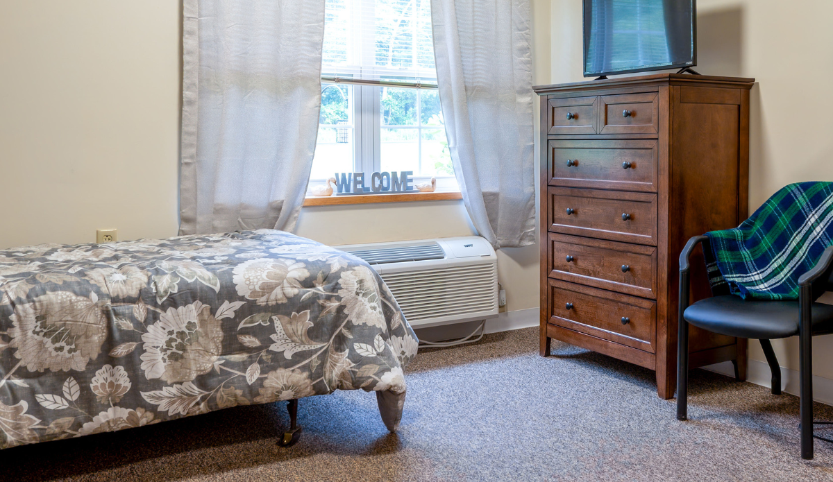 Cozy resident bedroom with floral bedding and dresser