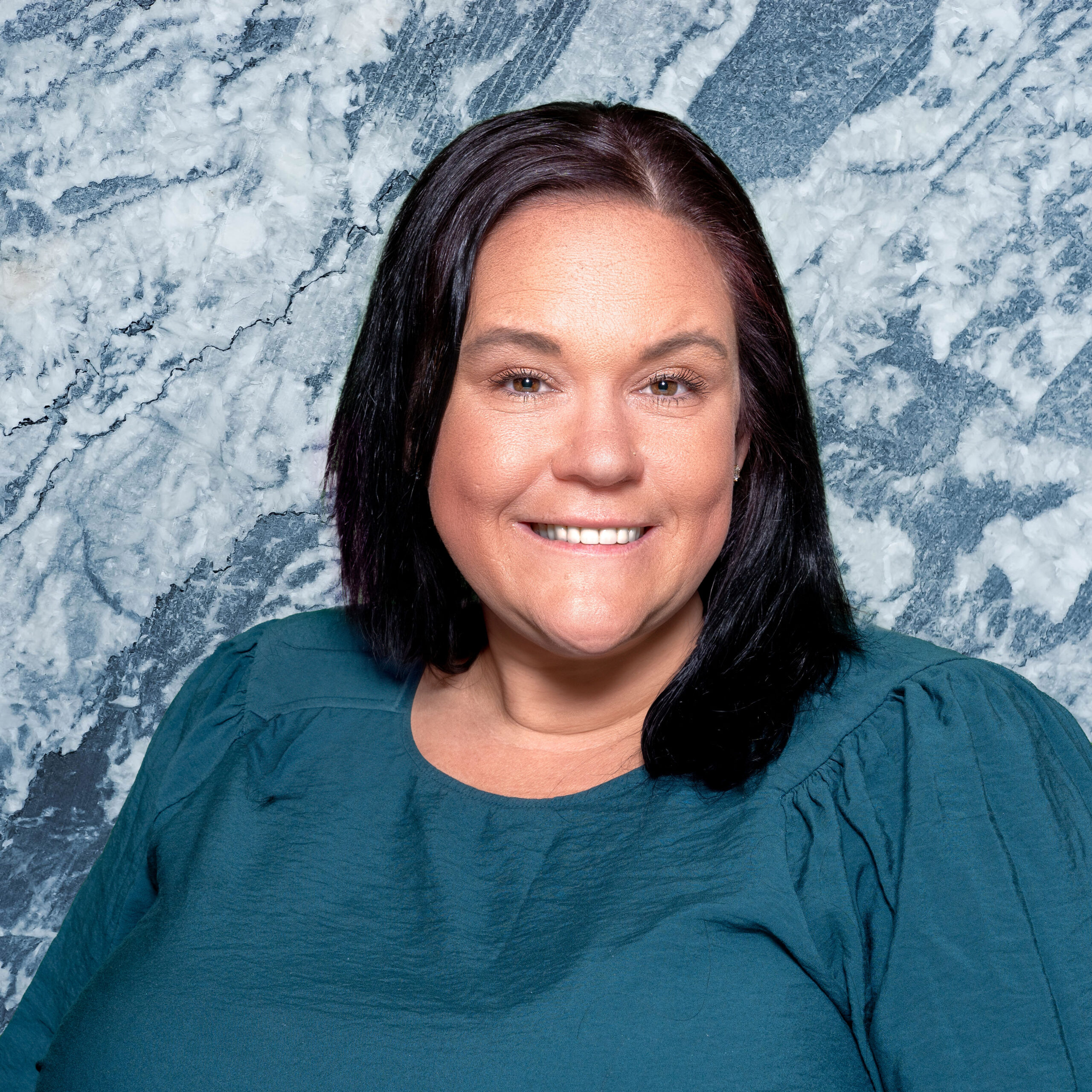 Smiling staff member in a teal top
