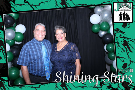 Two people posing at a festive event.