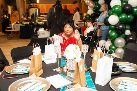 Senior resident enjoying a celebration in a decorated hall.