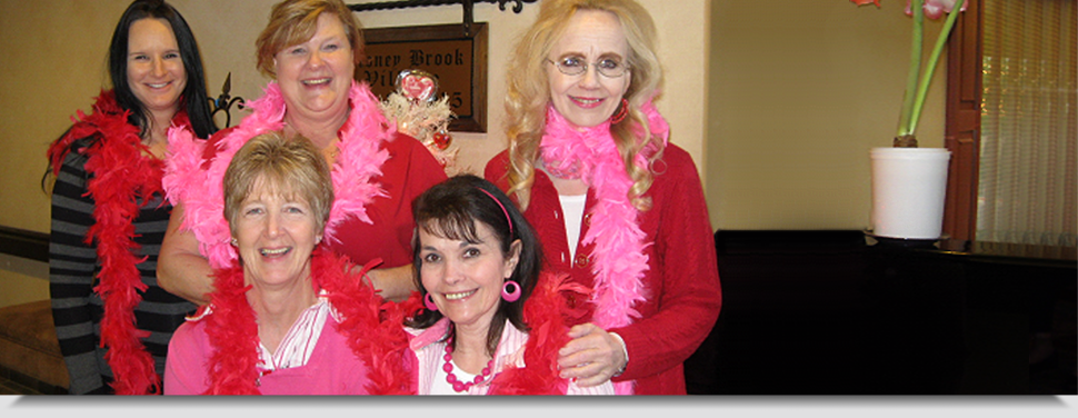 Staff members celebrating in pink accessories.