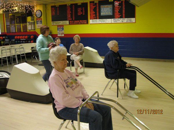 Residents participating in a bowling activity indoors.
