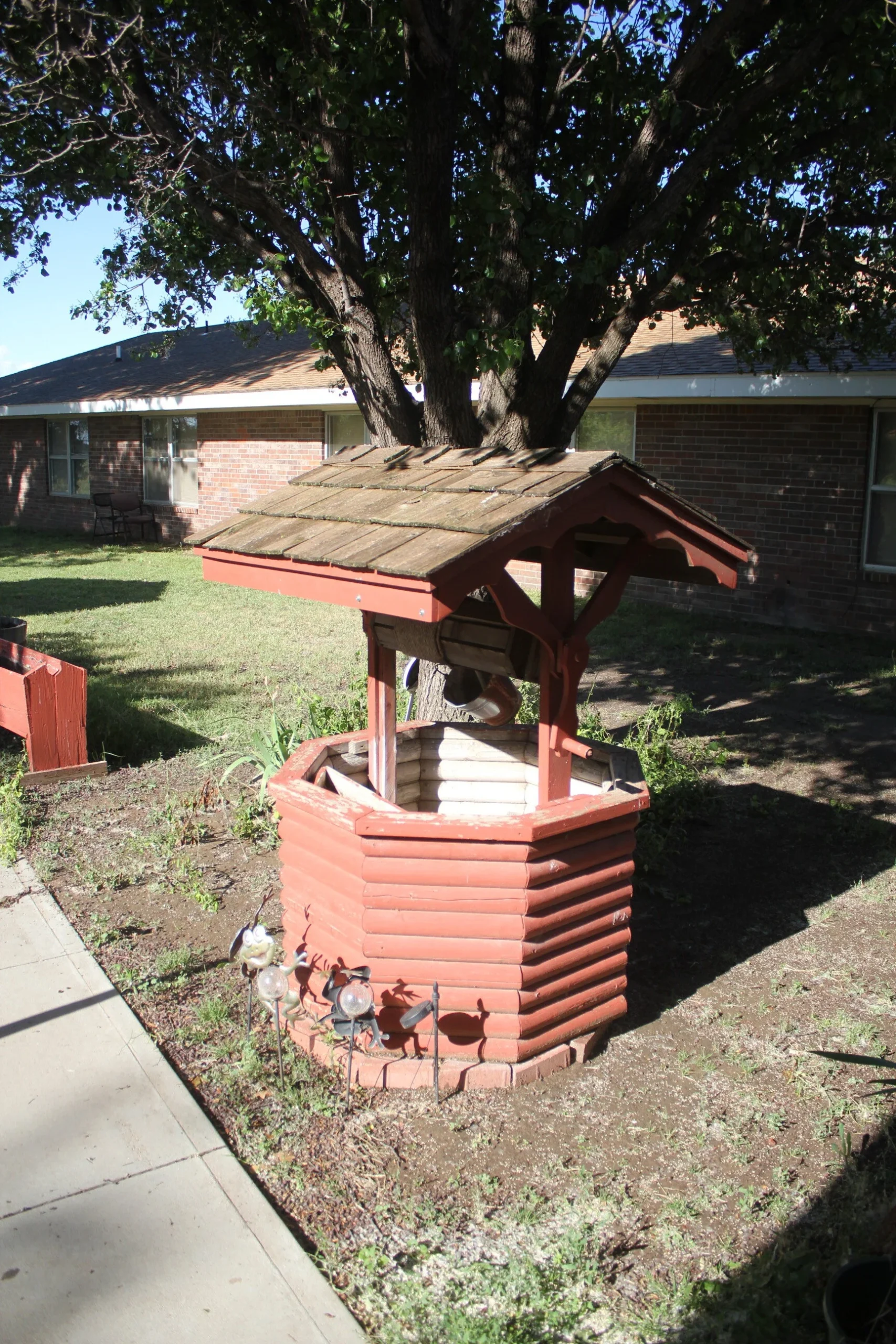 Outdoor wishing well surrounded by grass.