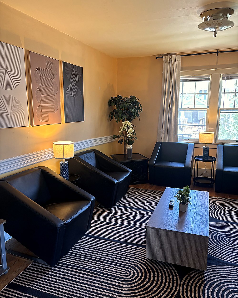 Cozy lounge area with black chairs and decorative accents.