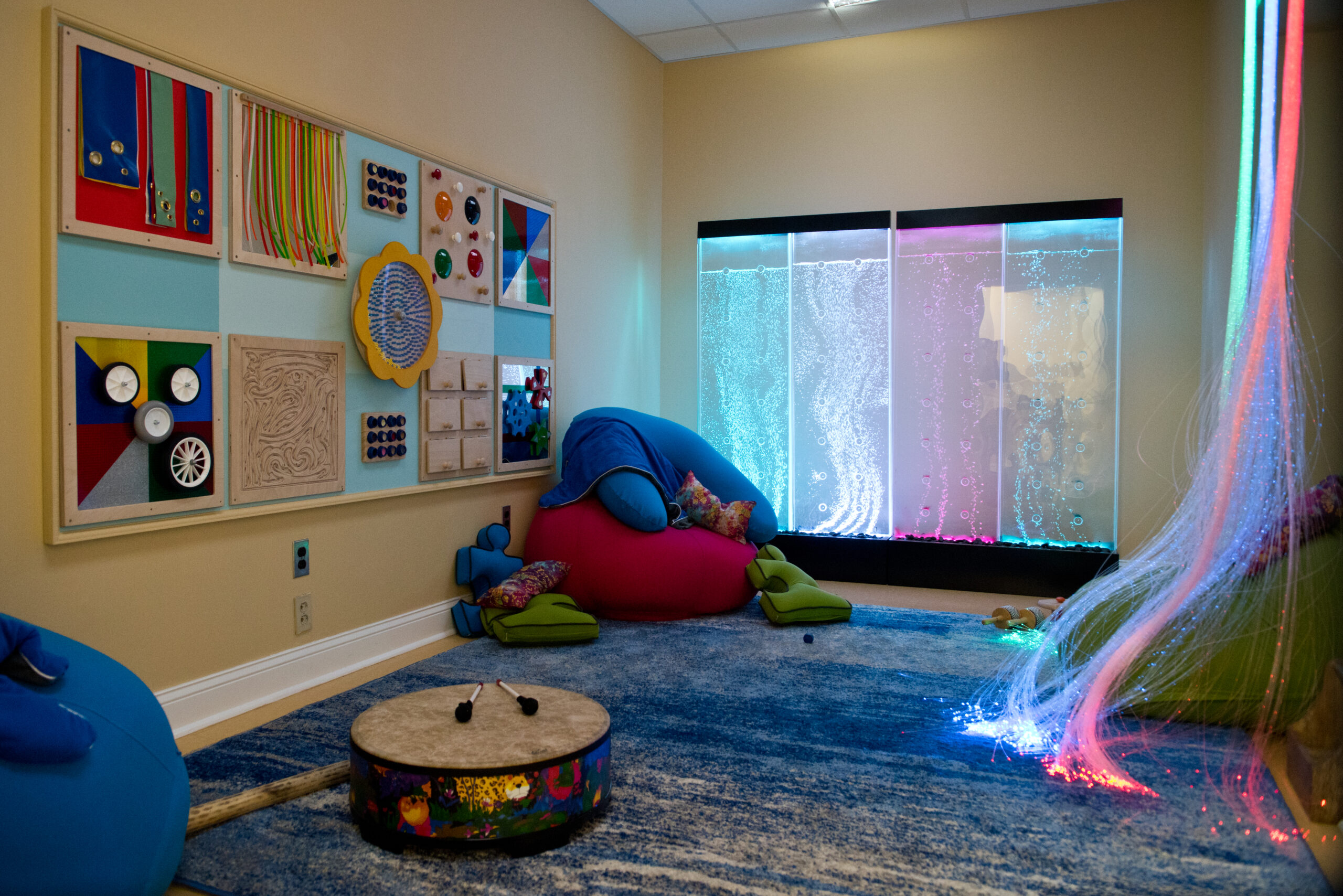 Bright sensory room with colorful decor and an aquarium.