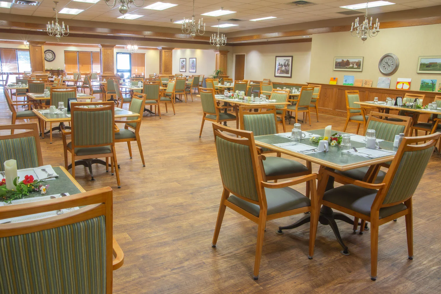 Dining room with tables and chairs set for a meal.