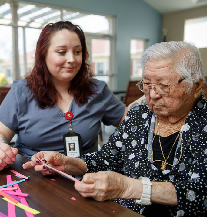 Staff member engaging with a resident during an activity.