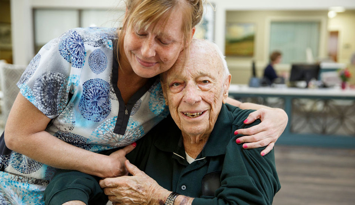Staff member embracing a resident in a common area