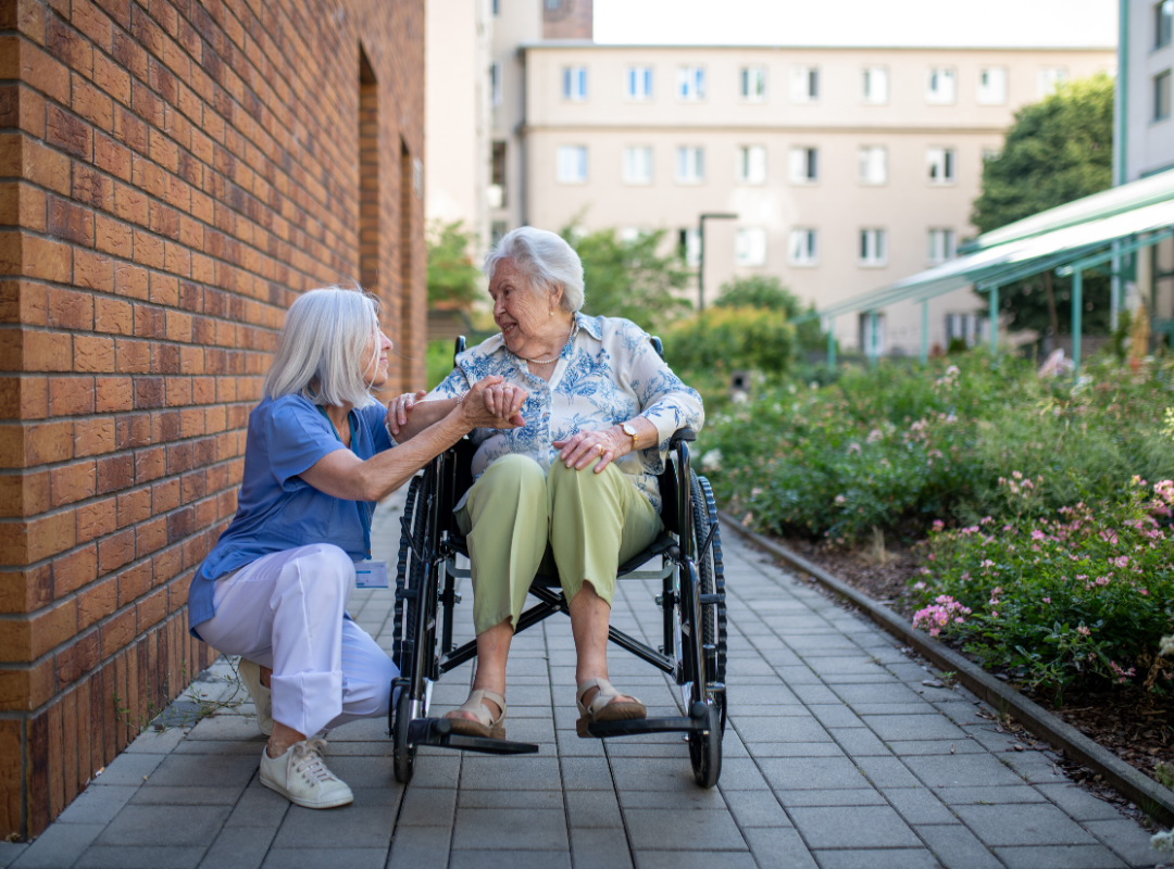 Staff member assisting a resident in a garden area