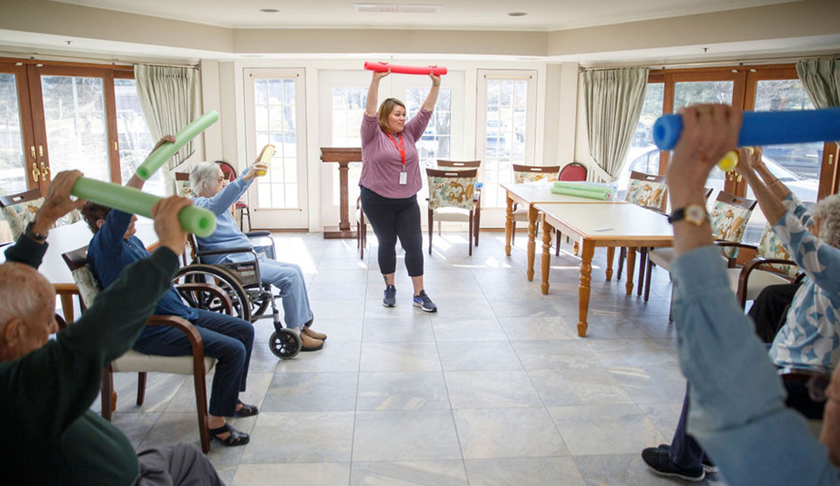 Residents participating in a fitness activity with a staff member.