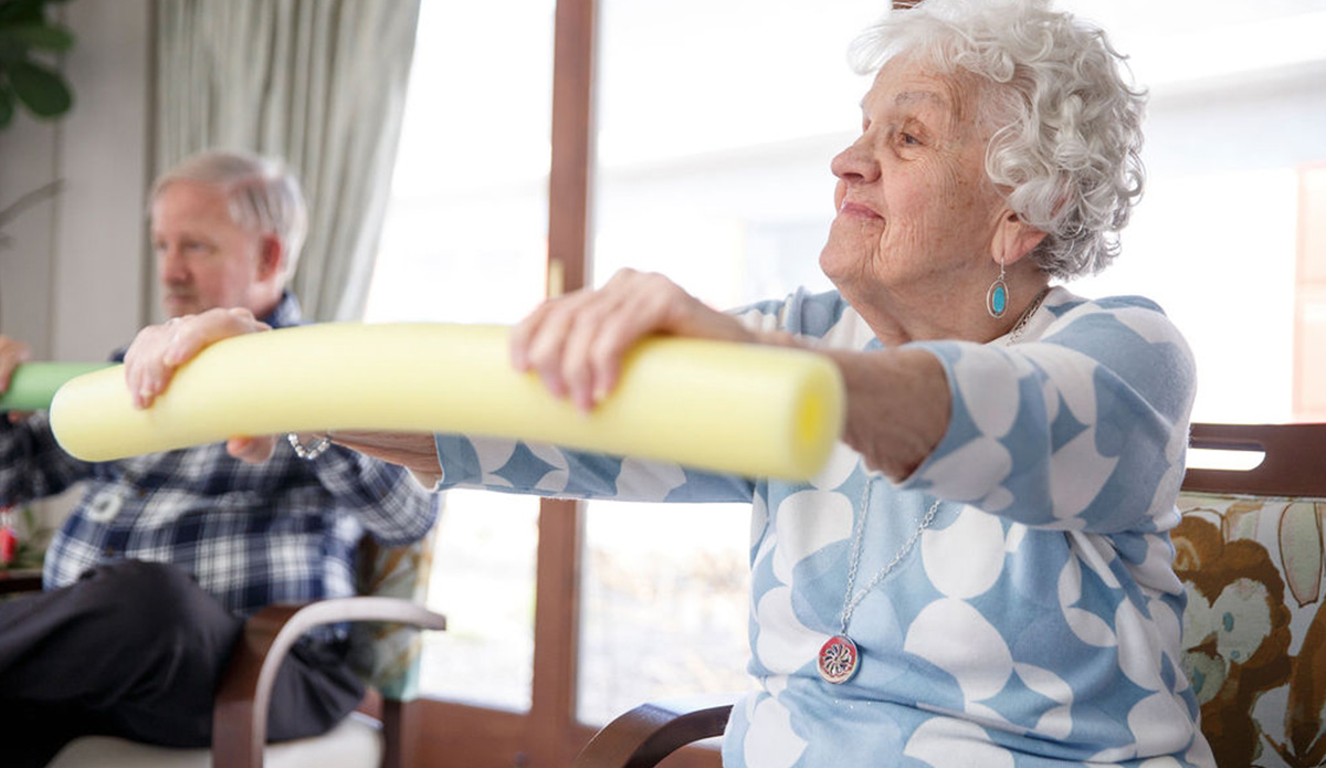 Seniors engaged in an exercise activity indoors.