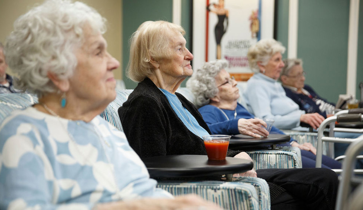 Elderly women enjoying a gathering indoors.