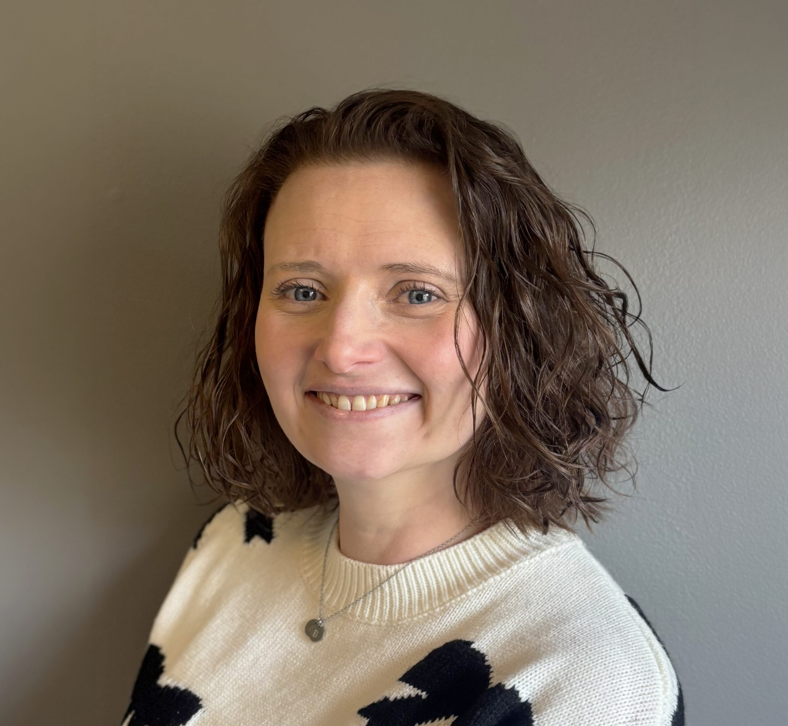 Smiling staff member in a casual sweater