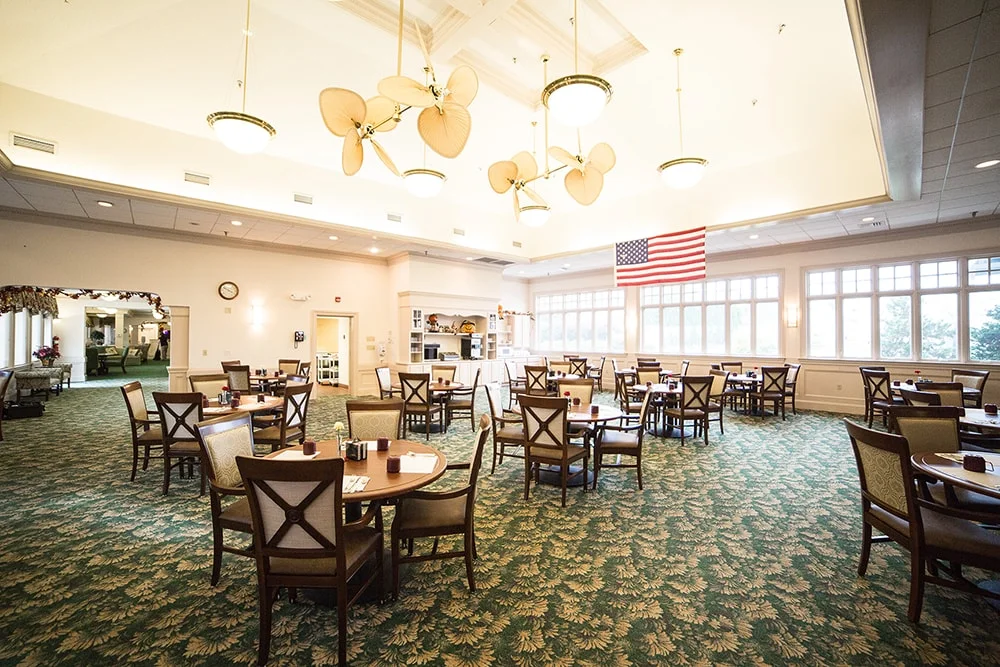 Dining area with tables and chairs and an American flag.