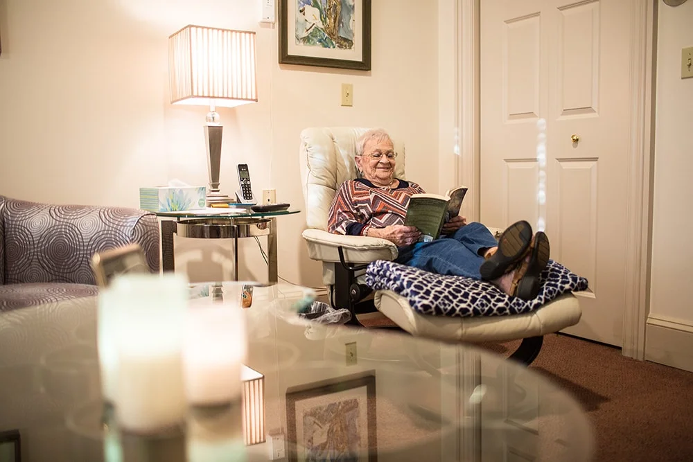 Elderly woman reading in a cozy chair.