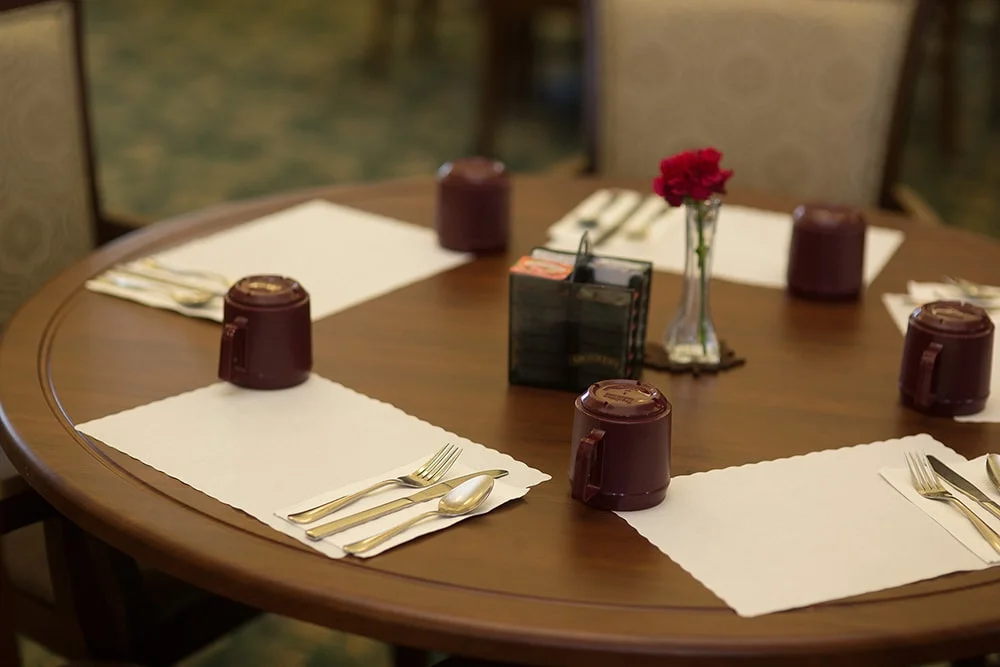 Dining table set for a meal with flowers.