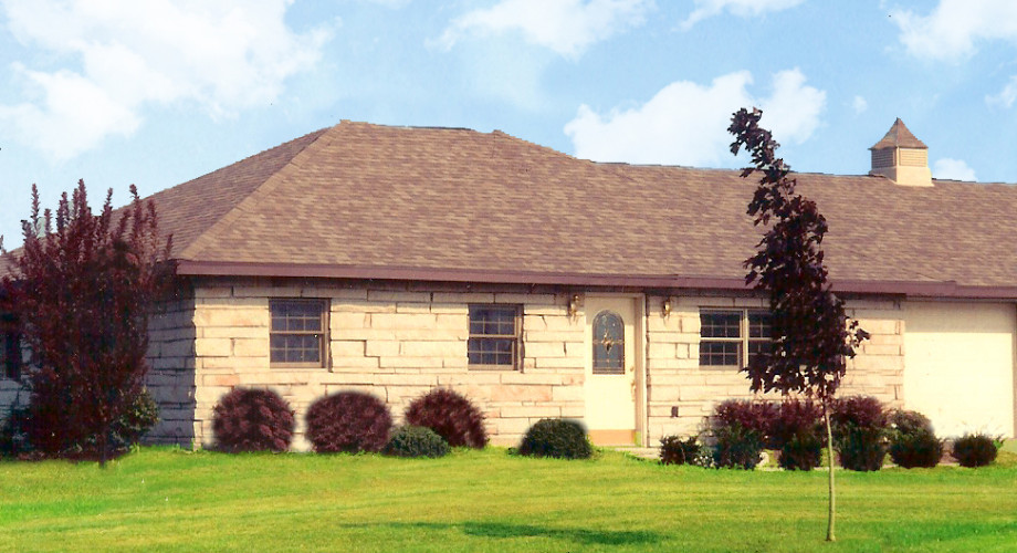 Exterior view of a facility building surrounded by grass.