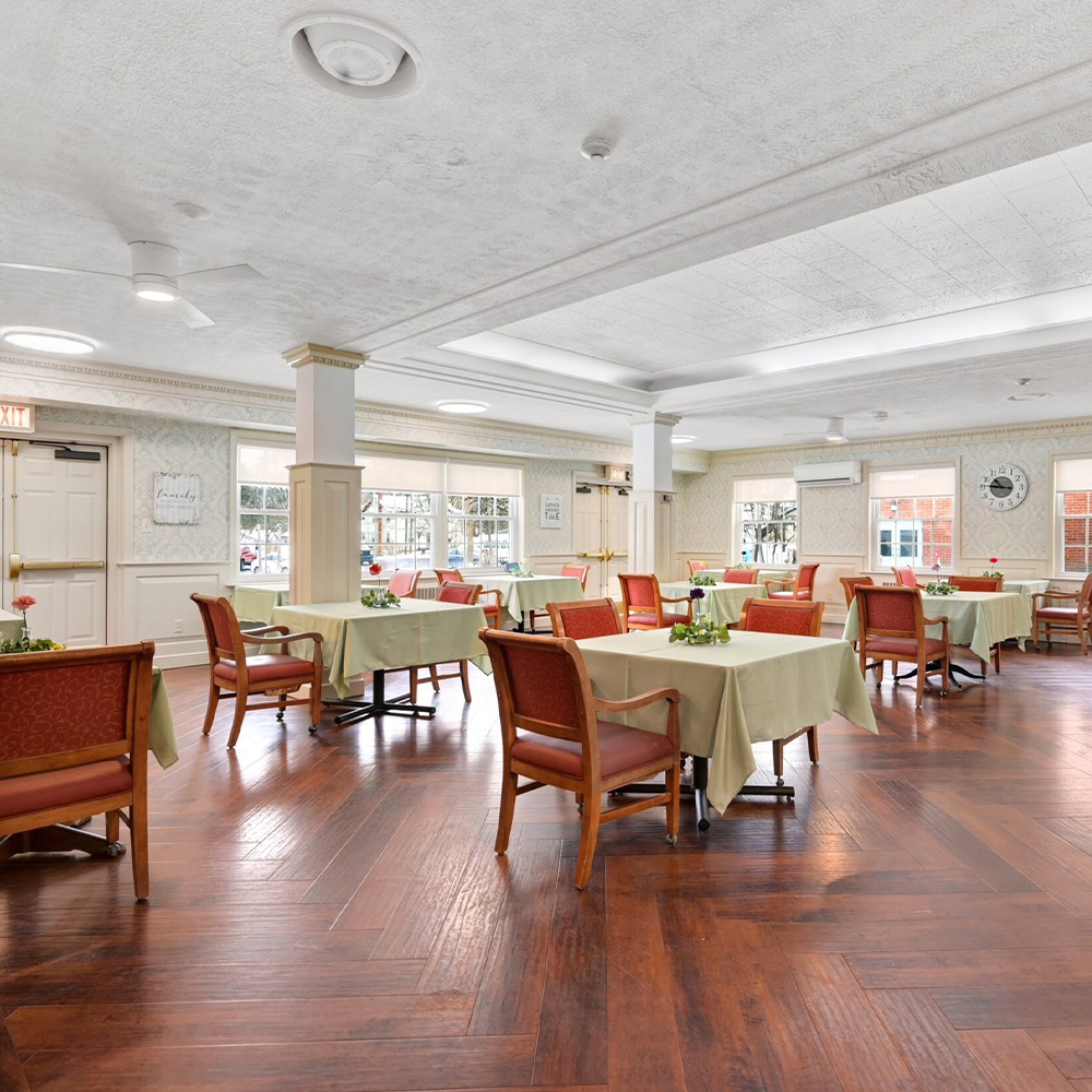 Dining area with tables and chairs set for meals.