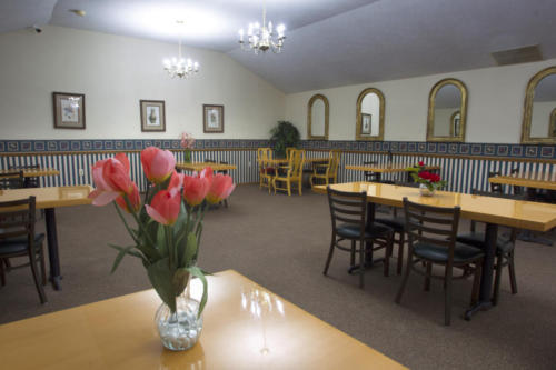 Bright dining room with flowers and tables.