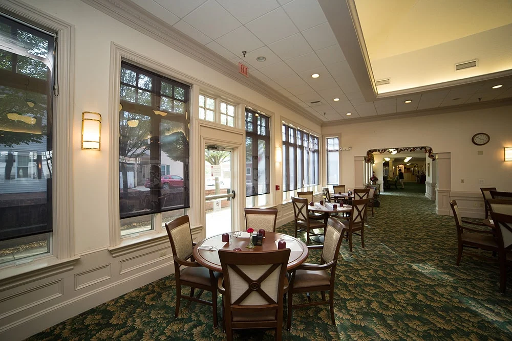 Dining area with tables and chairs in bright natural light.
