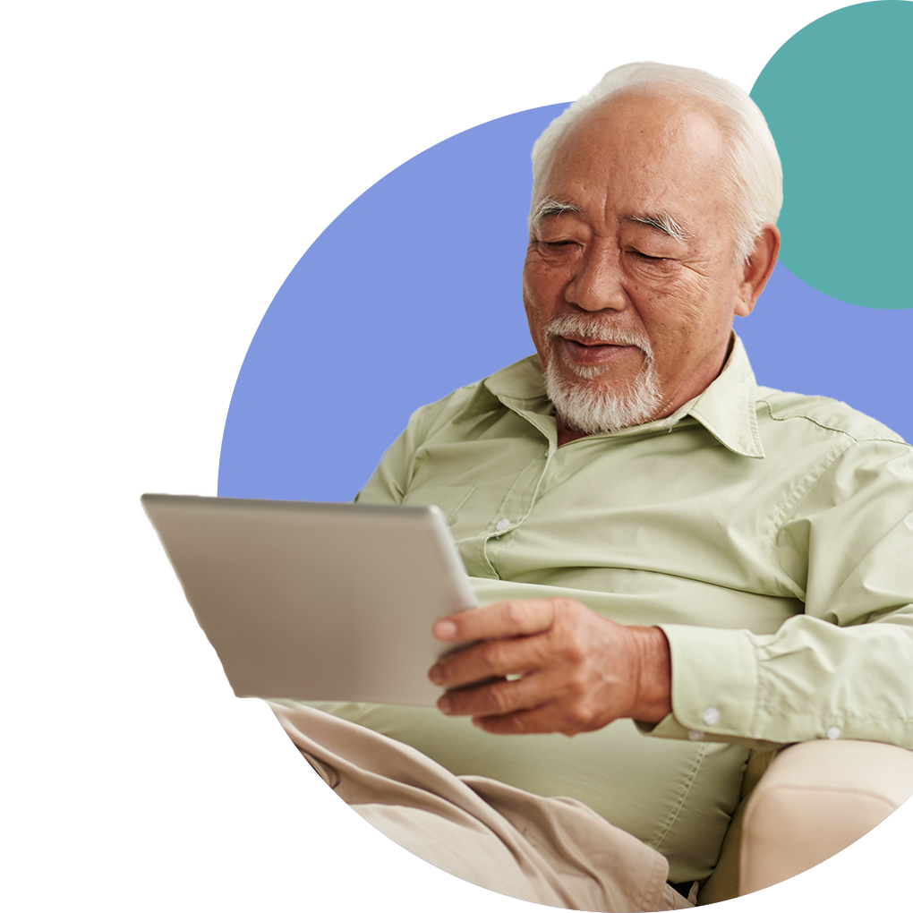 Senior man using a tablet, smiling.