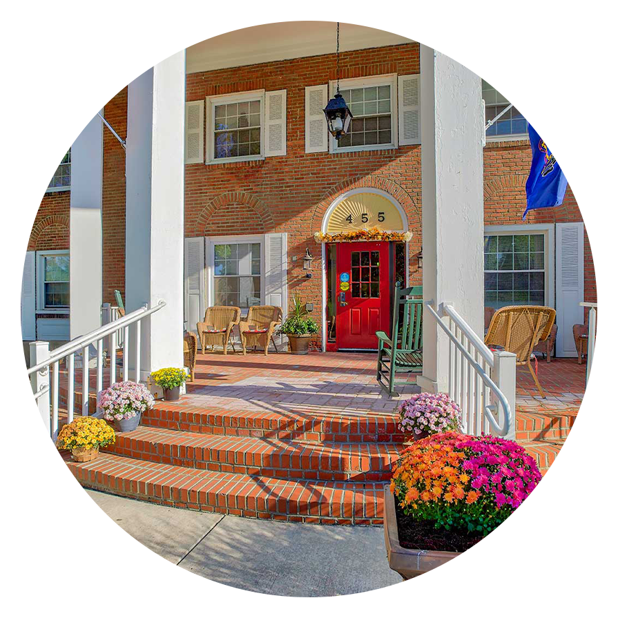 Front entrance with flowers and flags.