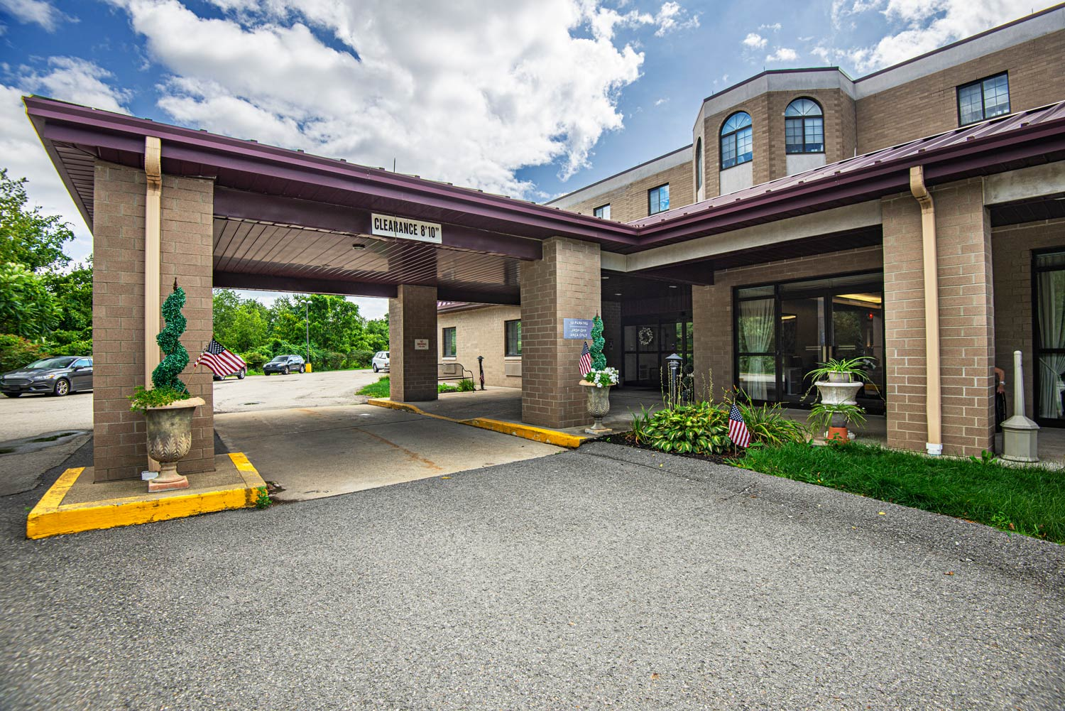 Building entrance with landscaping and parking area.