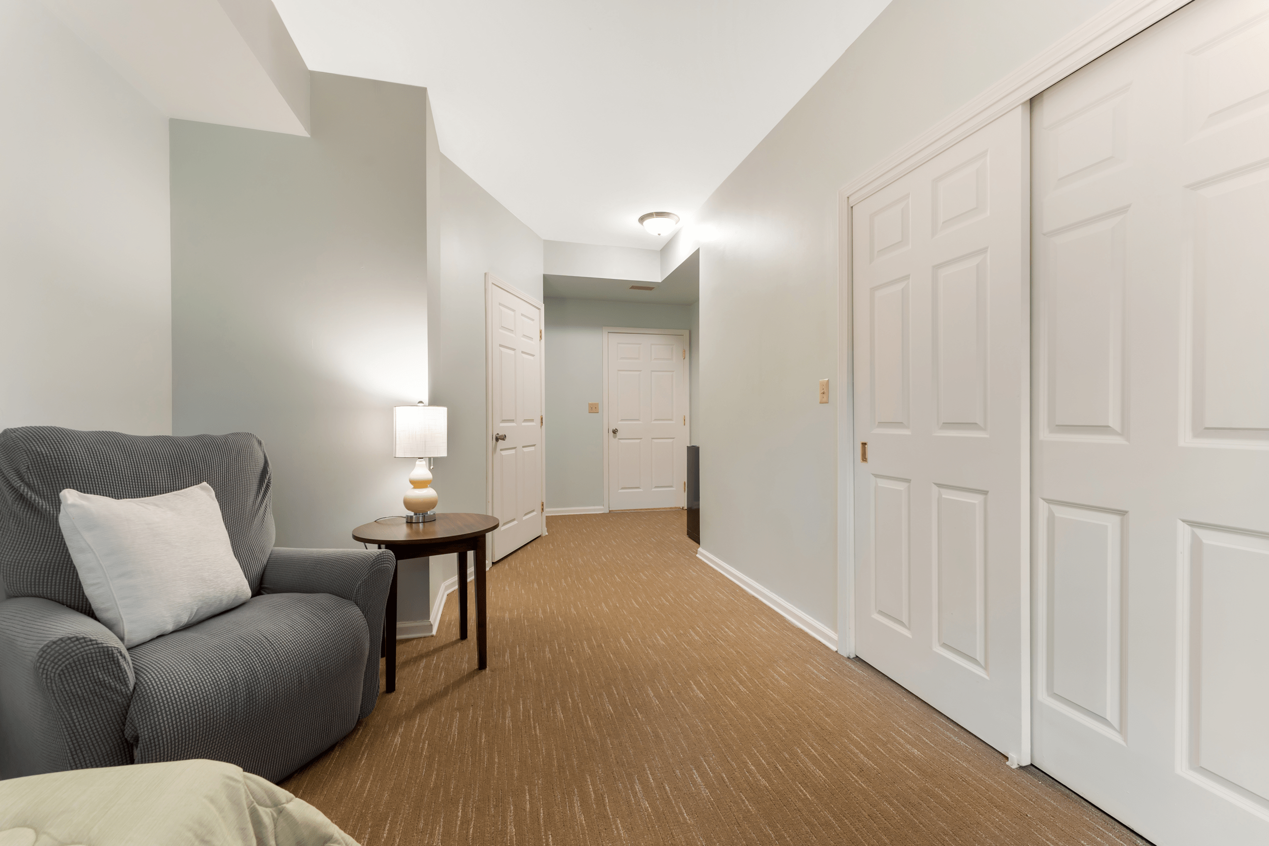 Interior hallway with a chair and lamp.