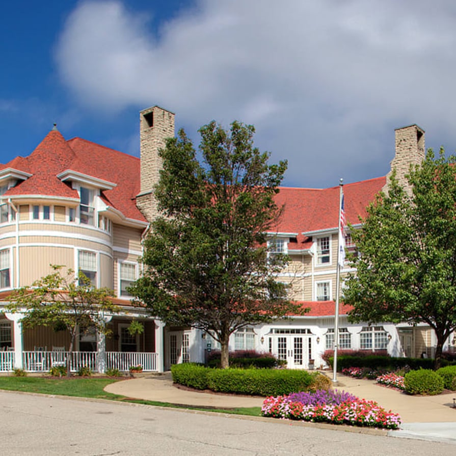 Exterior view of a senior living facility surrounded by flowers.
