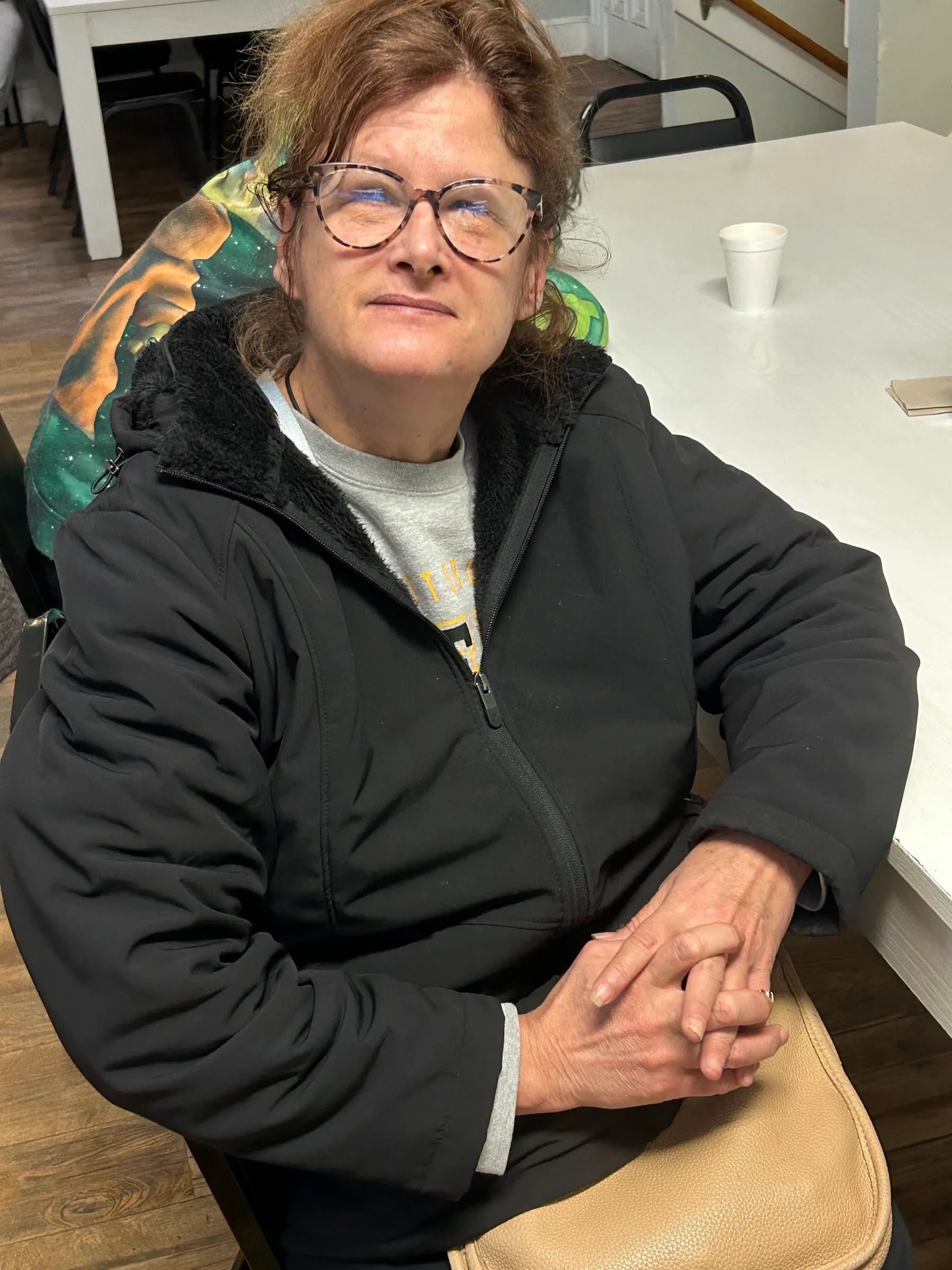 Resident sitting in a common area with a warm expression.