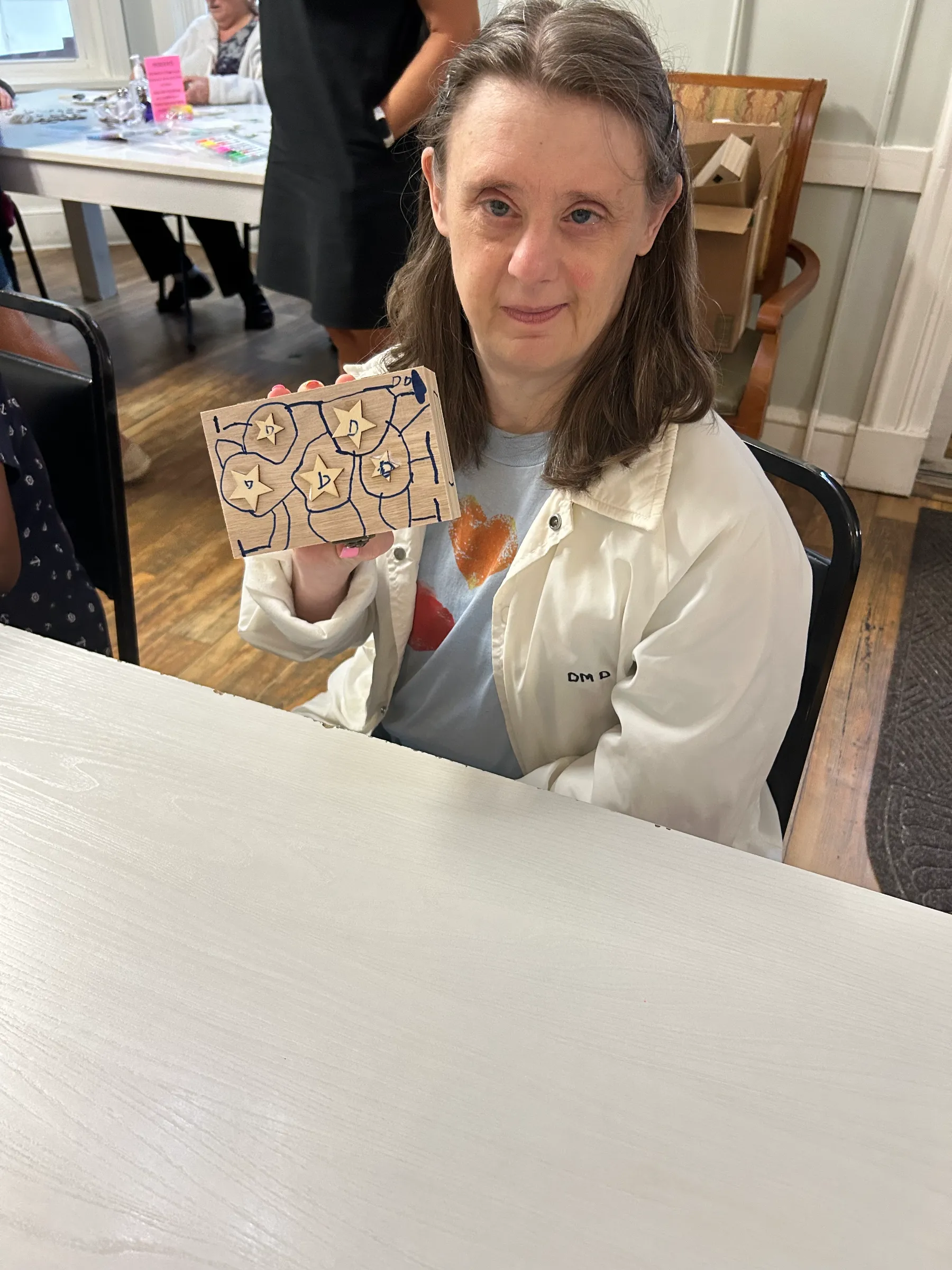 Resident holding a handmade craft project.