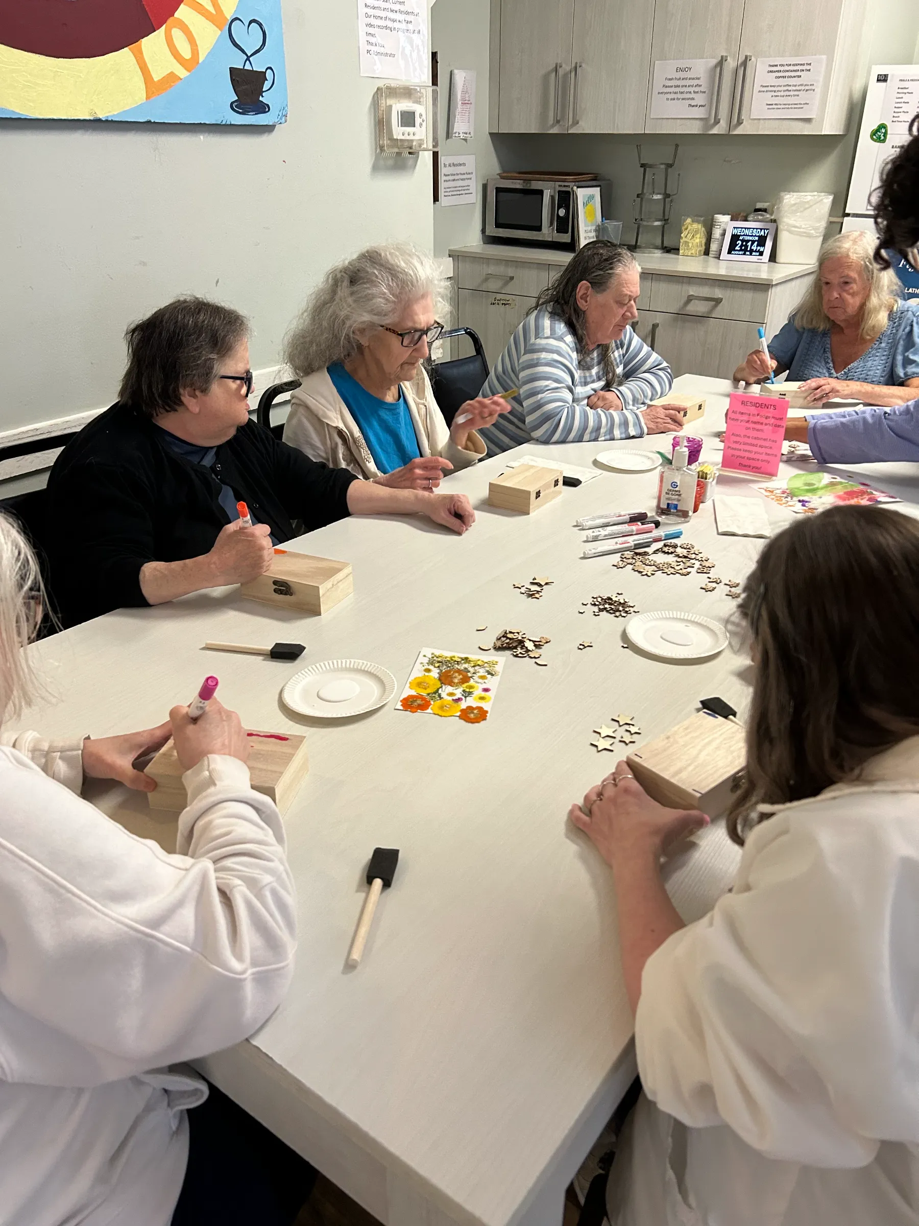 Residents engaged in a craft activity at a table.