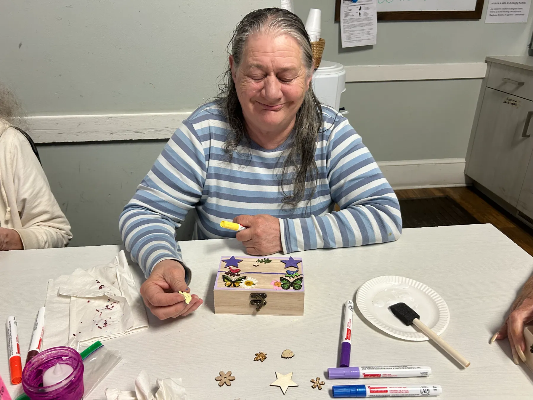Resident engaged in a craft activity at a table.